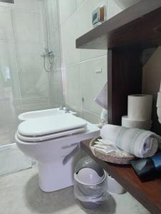a white bathroom with a toilet and a shower at Departamentos M&A 1 in Puerto Rico