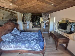 a bedroom with a bed and a mirror and a table at Chalet de la vallée in Souppes-sur-Loing