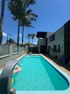 a swimming pool in front of a building at Suíte Floresta - Pousada Castelo do Luar in Penha