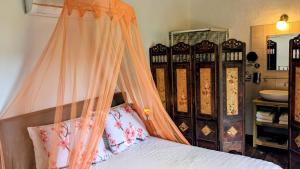 a bedroom with a bed with an orange canopy at La Cañota 2-Floors King Rooms Adults Only in Talara