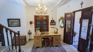 a home office with a desk and a chandelier at La Cañota 2-Floors King Rooms Adults Only in Talara