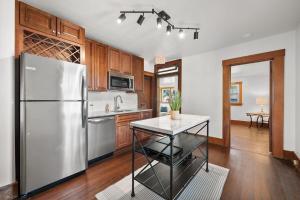 a kitchen with a stainless steel refrigerator and wooden cabinets at The Barker Bungalow in St. Charles