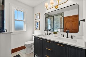 a bathroom with a sink and a toilet and a mirror at The Barker Bungalow in St. Charles +22 photos