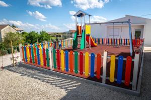 a playground with a colorful fence and a slide at Casa do Santo Estevão in Macedo de Cavaleiros