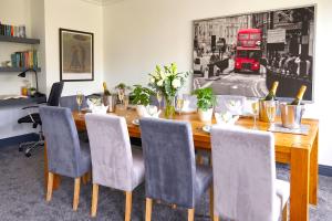 a dining room table with chairs and a red bus at Green Haven Villa - 4BR Spacious House with Hot tub, Ample Parking, Air Condition, WIFI, Netflix, Patio & Garden in Oxford