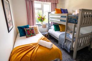 a room with two bunk beds and a window at Green Haven Villa - 4BR Spacious House with Hot tub, Ample Parking, Air Condition, WIFI, Netflix, Patio & Garden in Oxford +38 photos