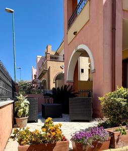 a patio with potted plants and a building at APPARTAMENTO PICASSO in Villasimius