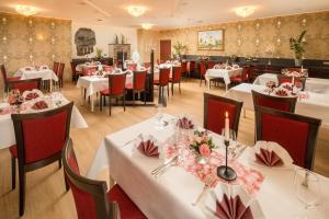 a restaurant with white tables and red chairs at Schlosshotel Klaffenbach in Chemnitz