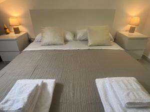 a bedroom with a large bed with white sheets and pillows at Santicelli 12 in Soverato Marina