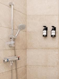 a shower with a shower head and two lights at Le Clos Lassagne -Terrasse privative - Climatisation - Lyon Sud - Brignais in Brignais