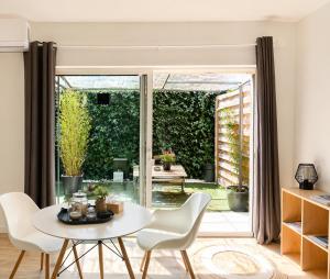 a living room with a table and chairs and a sliding glass door at Le Clos Lassagne -Terrasse privative - Climatisation - Lyon Sud - Brignais in Brignais