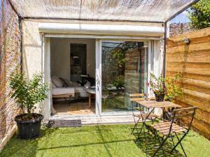 a patio with a table and chairs in a garden at Le Clos Lassagne -Terrasse privative - Climatisation - Lyon Sud - Brignais in Brignais