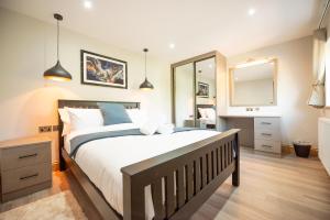 a bedroom with a large bed and a mirror at Hazel Lodge in Reading