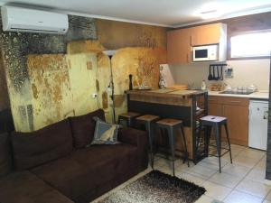 a living room with a couch and a kitchen at Lena Lodge in Fonyód