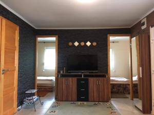 a living room with a television on a wall at Lena Lodge in Fonyód