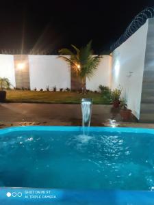 a water fountain in a pool at night at Casa Oliveira in Montes Claros