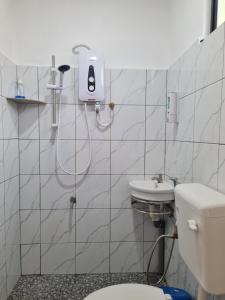 a bathroom with a toilet and a sink at Mutodon Green in Kuala Penyu
