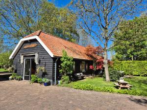 a small black building with a picnic table in front of it at Gastenverblijf de Bloesem privé appartement in Lunteren
