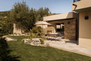 a garden with a table and an umbrella at Villa Nebbiu Vista in Oletta