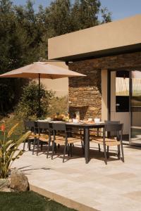 a table and chairs with an umbrella on a patio at Villa Nebbiu Vista in Oletta +23 photos