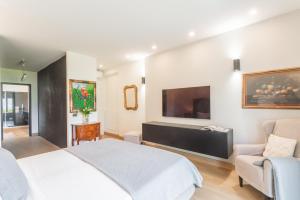 a bedroom with a bed and a flat screen tv at Villa Chiara in Stresa +34 photos