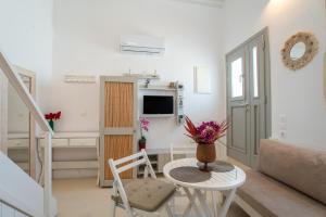 a white living room with a table and a couch at Anna's Apartment Marmara Paros in Kampos Paros