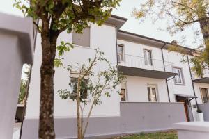 a white building with a tree in front of it at Dante Suites in Pergola