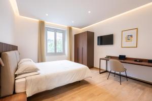 a bedroom with a bed and a desk and a chair at Dante Suites in Pergola