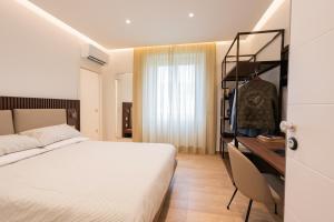a bedroom with a bed and a desk and a dresser at Dante Suites in Pergola