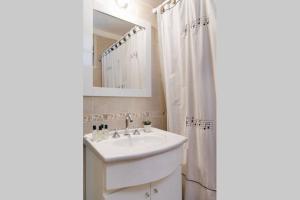 ブエノスアイレスにあるDepartamento Maria Paulaの洗面台と鏡のある白いバスルーム