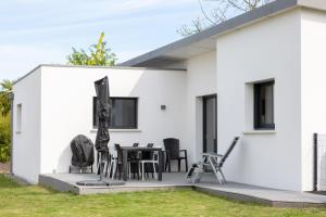 a white house with a table and chairs at Maison neuve pmr proche plage in Concarneau