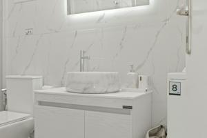 a white bathroom with a sink and a mirror at Cassiopeia in Akrotiri
