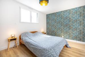 a bedroom with a bed with a blue tiled wall at Maison neuve pmr proche plage in Concarneau