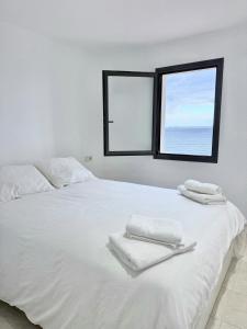 a white bed with two towels on top of it at Apartamentos Stella Maris in Roses