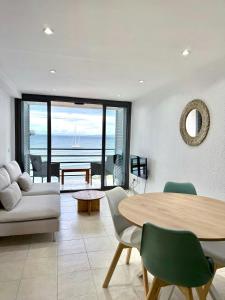 a living room with a table and a view of the ocean at Apartamentos Stella Maris in Roses