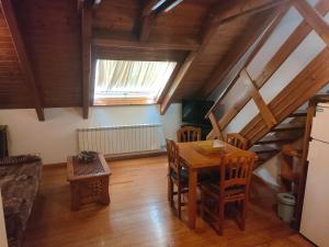 a dining room with a table and chairs and a window at Barruera duplex 2 bedrooms heating in Barruera