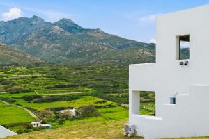 a white house with mountains in the background at Cassiopeia in Akrotiri