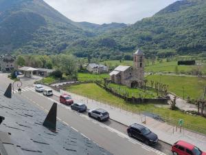 a street with cars parked in front of a church at Barruera duplex 2 bedrooms heating in Barruera +4 photos