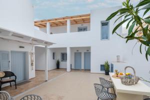 a white house with a dining area and a table and chairs at Begi Luxury Villas in Karterados