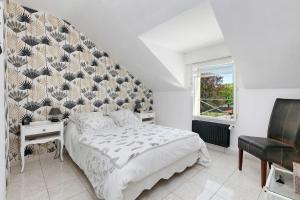 a bedroom with a bed with a large headboard at Chez Anne-Marie et Constant in Pornichet
