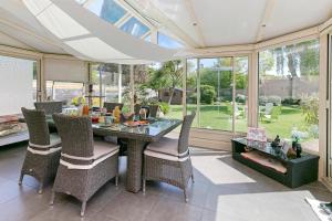 a dining room with a table and chairs and windows at Chez Anne-Marie et Constant in Pornichet