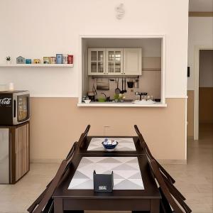 a dining room with a table and a kitchen at Margherita Rooms in Catania