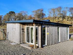 a small shed with a metal roof and glass doors at Faodail Studio in Portree