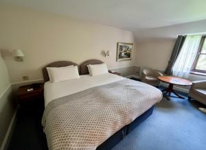 a bedroom with a large bed and a table at The Tollgate Hotel in Steyning