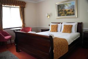 a hotel room with a bed and a red chair at The Tollgate Hotel in Steyning