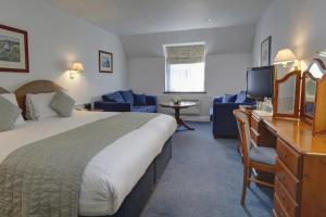 a hotel room with a large bed and a television at The Tollgate Hotel in Steyning