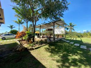 a garden with a pavilion and a car parked at CAMALEÃO Ecopousada Ltda in Linhares