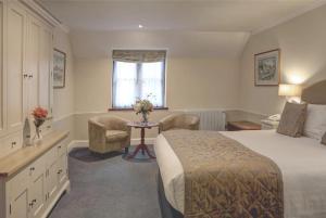 a hotel room with a bed and a table and chairs at The Tollgate Hotel in Steyning