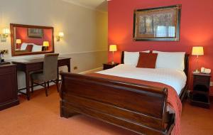 a bedroom with a bed and a desk and a mirror at The Tollgate Hotel in Steyning +4 photos