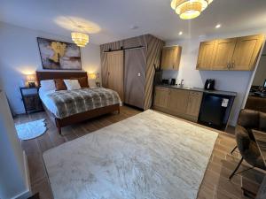 a bedroom with a bed and a kitchen in a room at Longovers Lodge in Westbourne